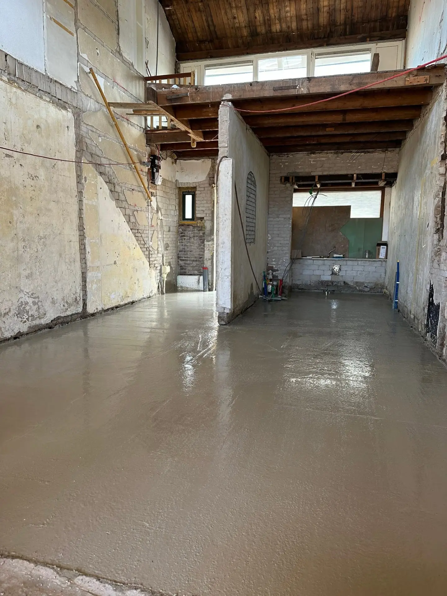 Eigen project: renovatie binnen met gestort beton en oude muren en balken